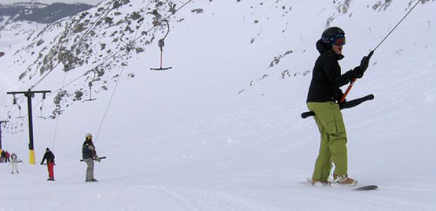 Een snowboarder gebruikt een sleeplift in Whistler
