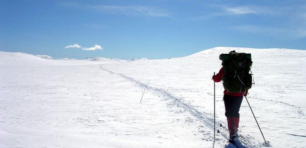 Een toerskiër begint aan de beklimming van een piste