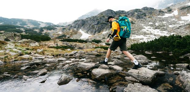 Yevhenii Dubrovskyi on Unsplash Persoon die in de bergen over een beekje springt