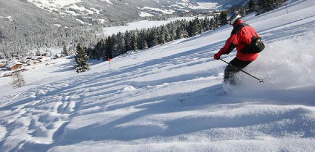 Een skiër begint aan een afdaling in de Zillertal Arena in Tirol - Oostenrijk.