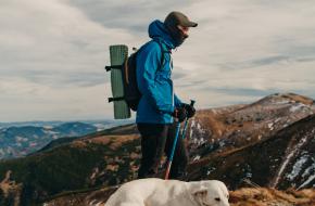 Een bergwandelaar met zijn hond