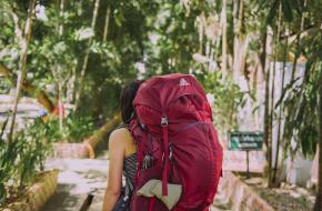 Foto Suhyeon Choi via Unsplash vrouw met een grote rode backpack