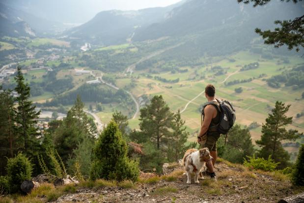 Hugo Carle on Unsplash Man en hond genieten van een uitzicht in de bergen